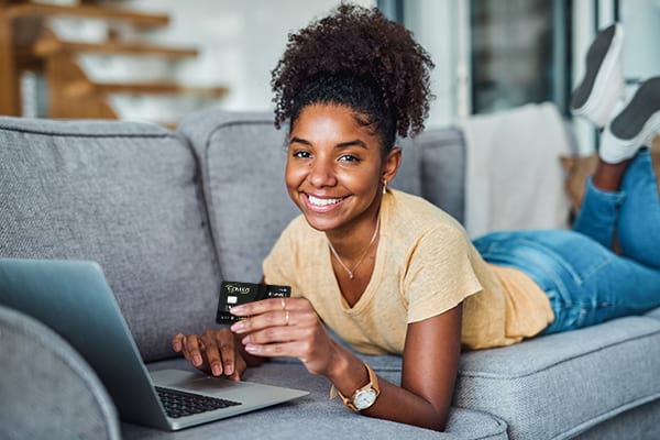 Teen on couch with credit card